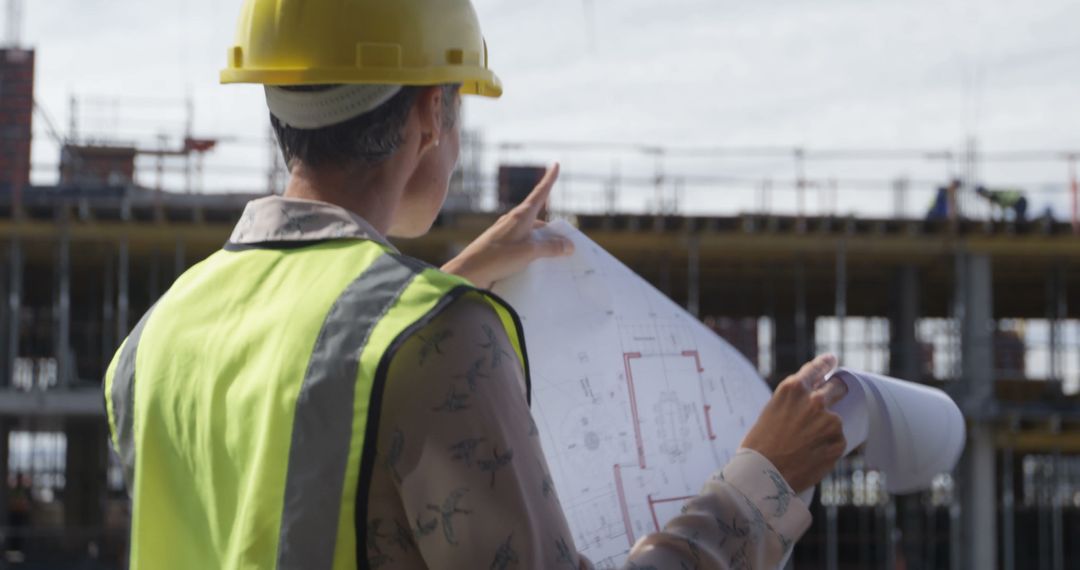 Construction Worker Analyzing Blueprints at Building Site - Free Images, Stock Photos and Pictures on Pikwizard.com