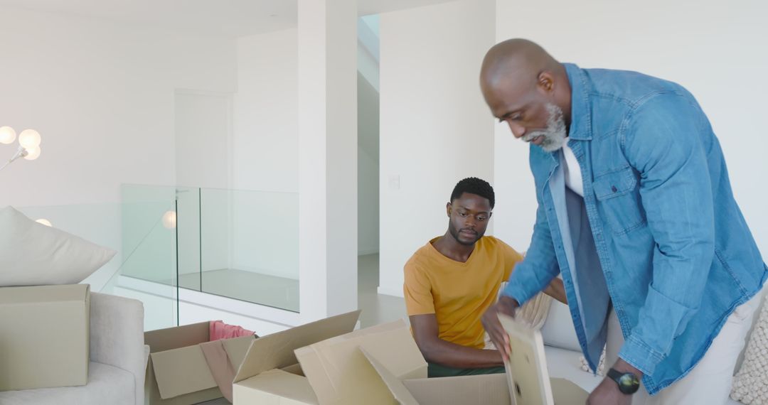 Father and Son Unpacking in Modern Home with Glass Accents