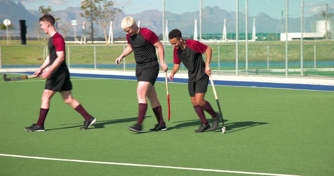 Young Male Field Hockey Players Walking on Turf in Team Uniforms