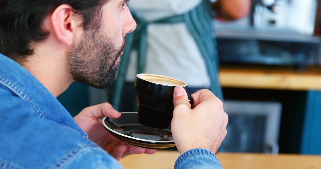 Man Drinking Coffee in Cafe Wearing Denim Jacket - Free Images, Stock Photos and Pictures on Pikwizard.com