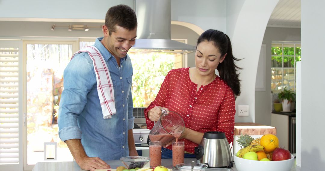 Smiling Couple Making Smoothies Together in Bright Kitchen