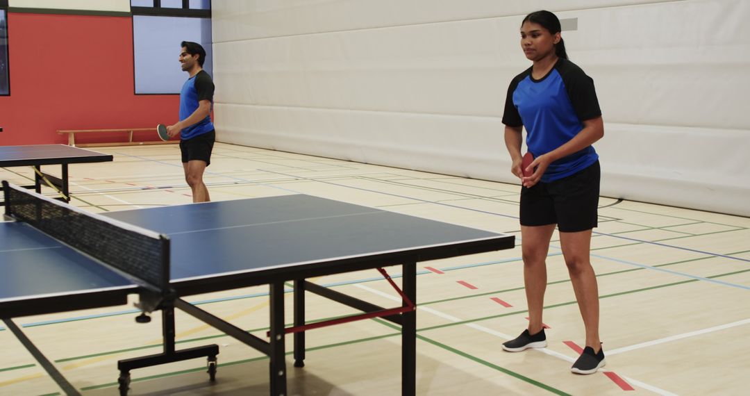 Diverse Team Practicing Table Tennis in Gym