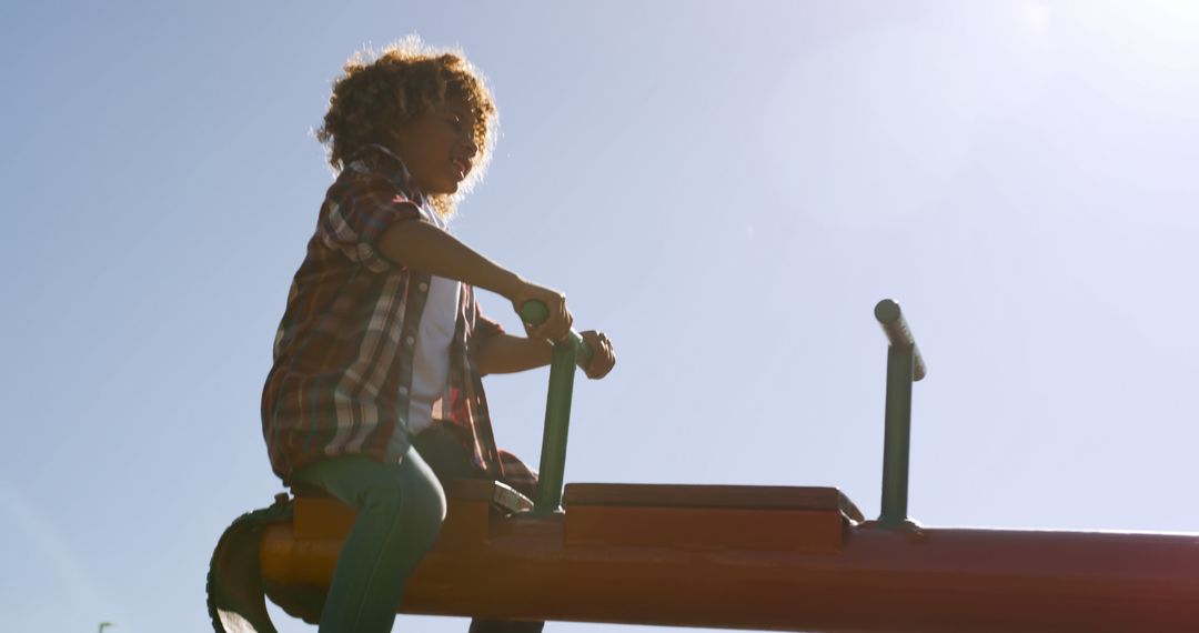 Happy Child Playing on a Seesaw in Sunny Playground - Free Images, Stock Photos and Pictures on Pikwizard.com