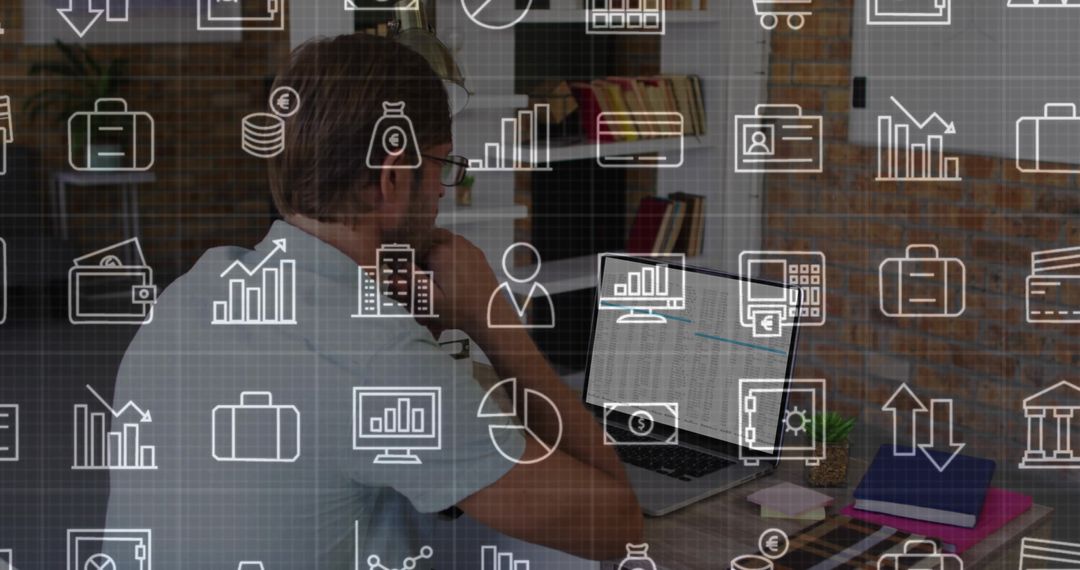 Midadult man resting chin while analyzing laptop and phone with finance icons overlaying