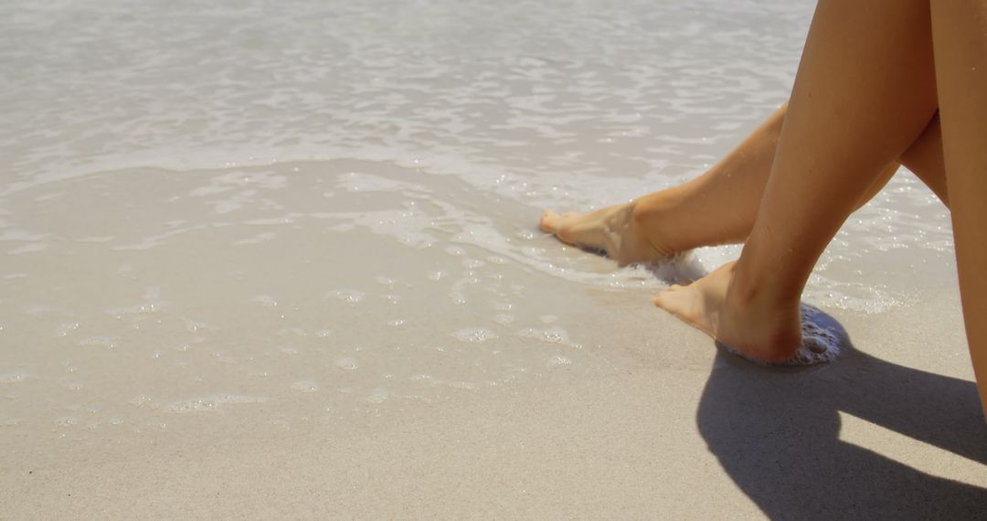 Woman's Feet Relaxing at Sandy Beach Waves