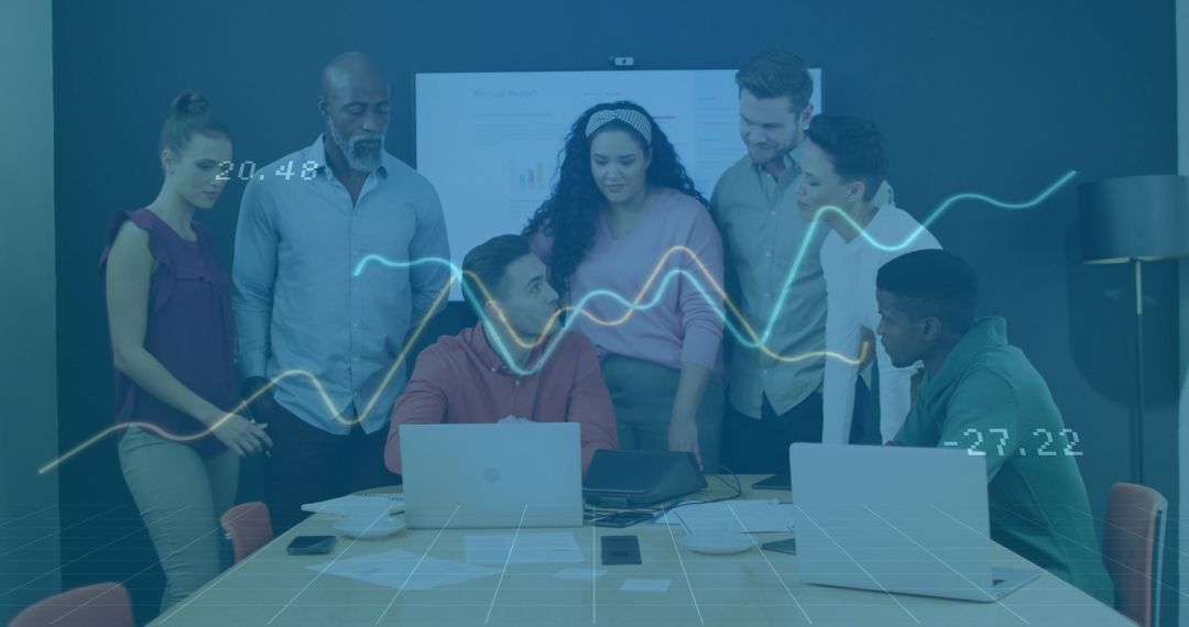 Diverse Team Analyzing Data With Technology in Modern Meeting