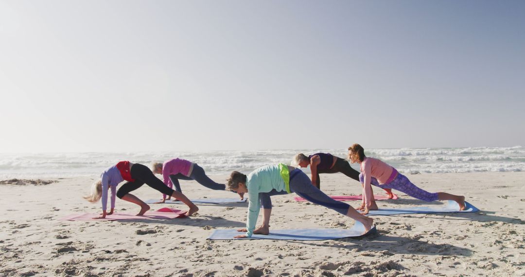 Diverse women wearing sports clothes doing yoga and stretching at beach - Free Images, Stock Photos and Pictures on Pikwizard.com