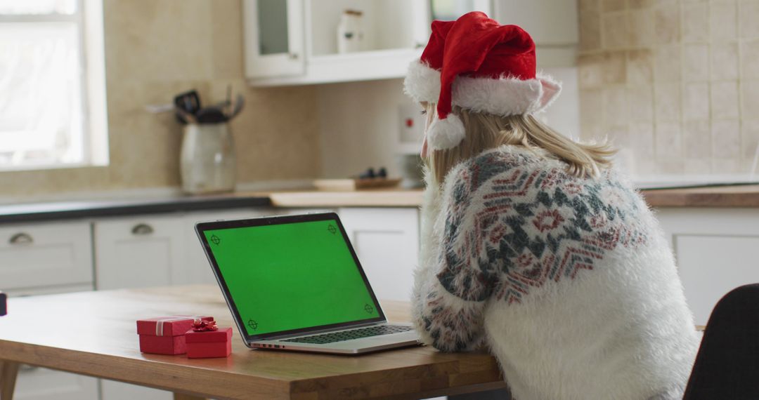 Woman Wearing Christmas Hat Using Laptop with Green Screen - Free Images, Stock Photos and Pictures on Pikwizard.com