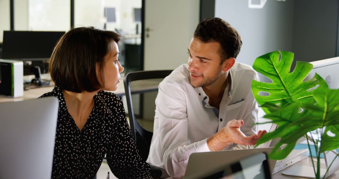 Two Colleagues Engaging in Discussion in Modern Office Environment - Free Images, Stock Photos and Pictures on Pikwizard.com