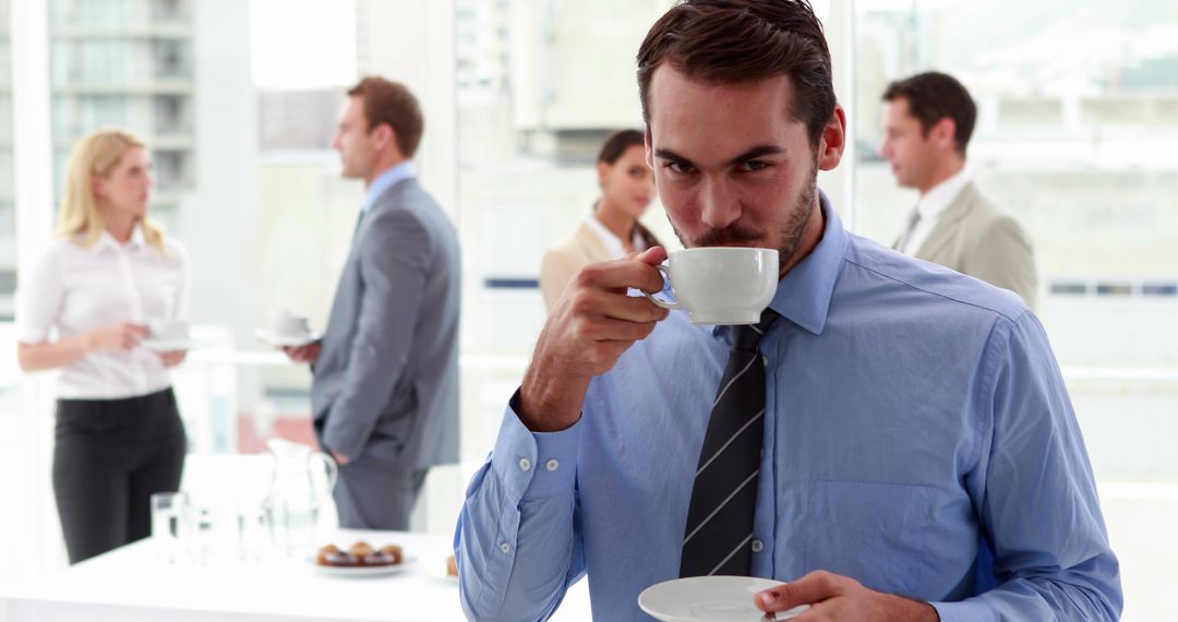 Businessman Drinking Coffee at Networking Event in Modern Office - Free Images, Stock Photos and Pictures on Pikwizard.com