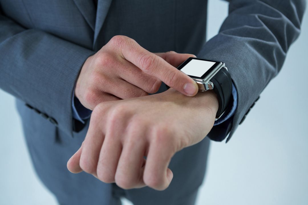 Businessman checking his smart watch - Free Images, Stock Photos and Pictures on Pikwizard.com