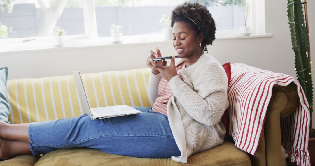 Relaxed Woman Using Smartphone and Laptop at Home