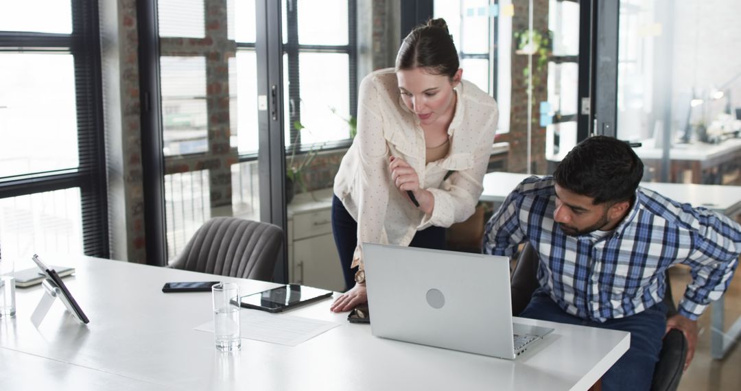 Colleagues Collaborating at Laptop in Modern Office