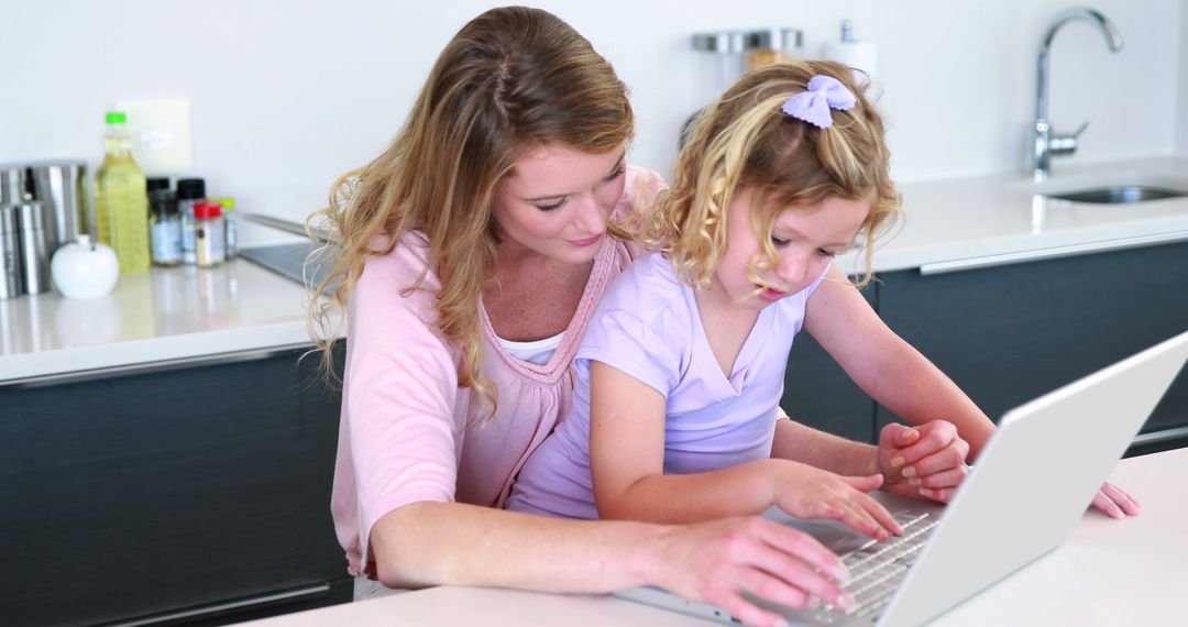 Mother and Daughter Using Laptop at Modern Kitchen Counter - Free Images, Stock Photos and Pictures on Pikwizard.com