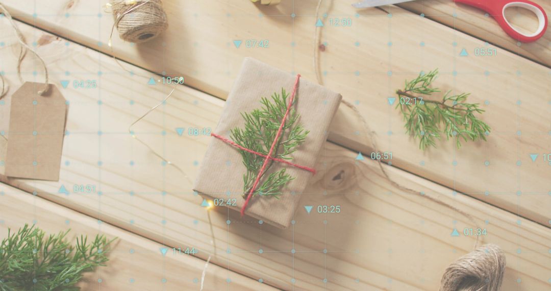 Featuring kraft-wrapped gift tied with red twine and green sprig on rustic wood tabletop