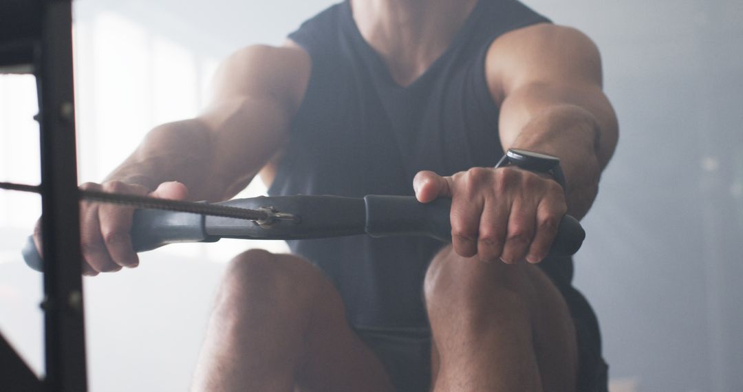 Muscular Man Focused on Vigorous Rowing Machine Workout
