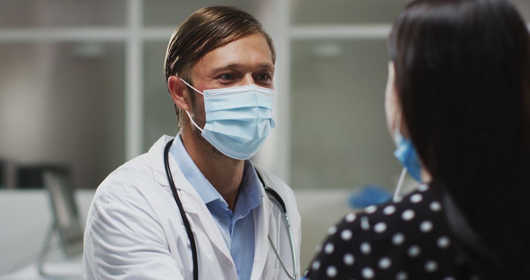 Doctor Consulting Patient in Medical Office While Wearing Masks - Free Images, Stock Photos and Pictures on Pikwizard.com