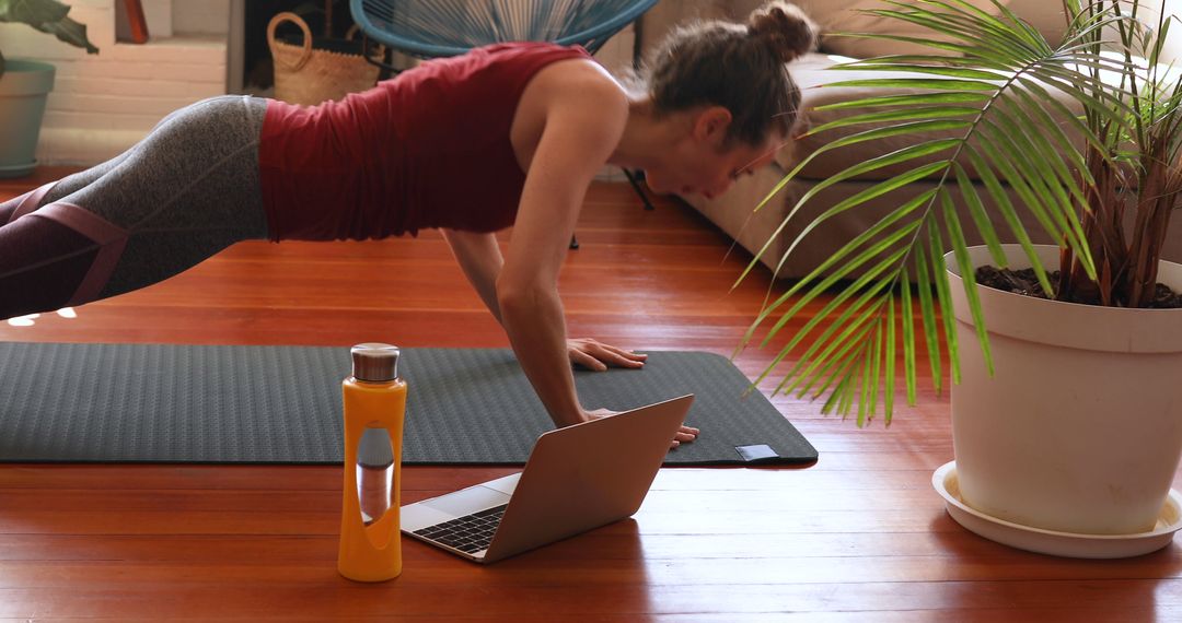 Young Woman Exercising at Home with Laptop and Water Bottle - Free Images, Stock Photos and Pictures on Pikwizard.com