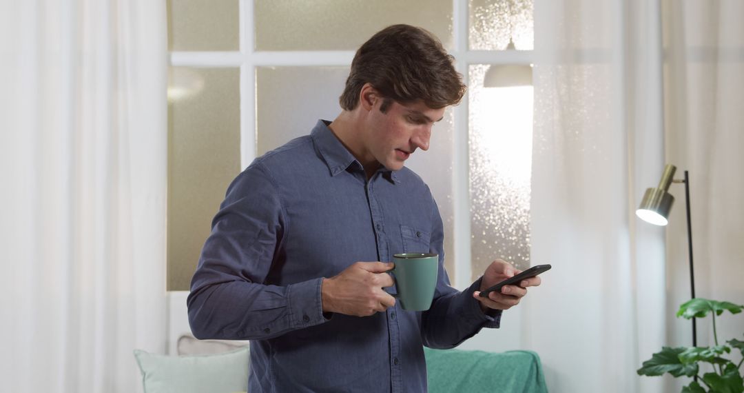 Man Drinking Coffee While Using Smartphone at Home - Free Images, Stock Photos and Pictures on Pikwizard.com