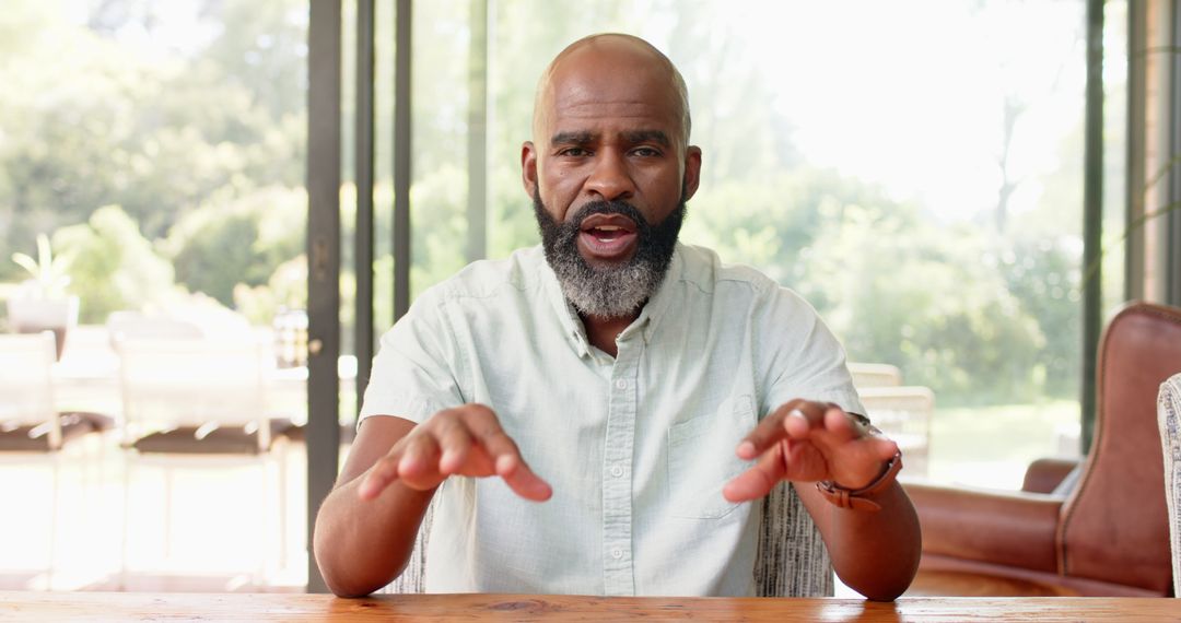 Senior Man Engaged in Expressive Conversation Indoors