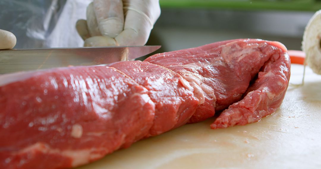 Butcher Cutting Fresh Red Meat on Wooden Board - Free Images, Stock Photos and Pictures on Pikwizard.com