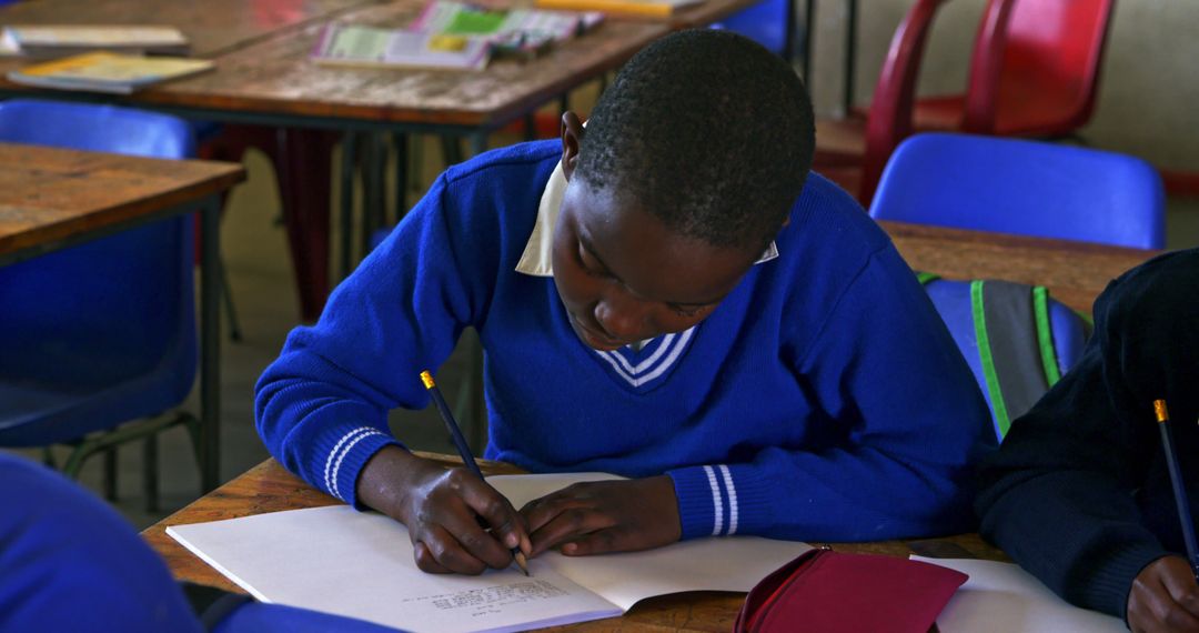 Attentive Schoolboy Writing Notes in Classroom - Free Images, Stock Photos and Pictures on Pikwizard.com