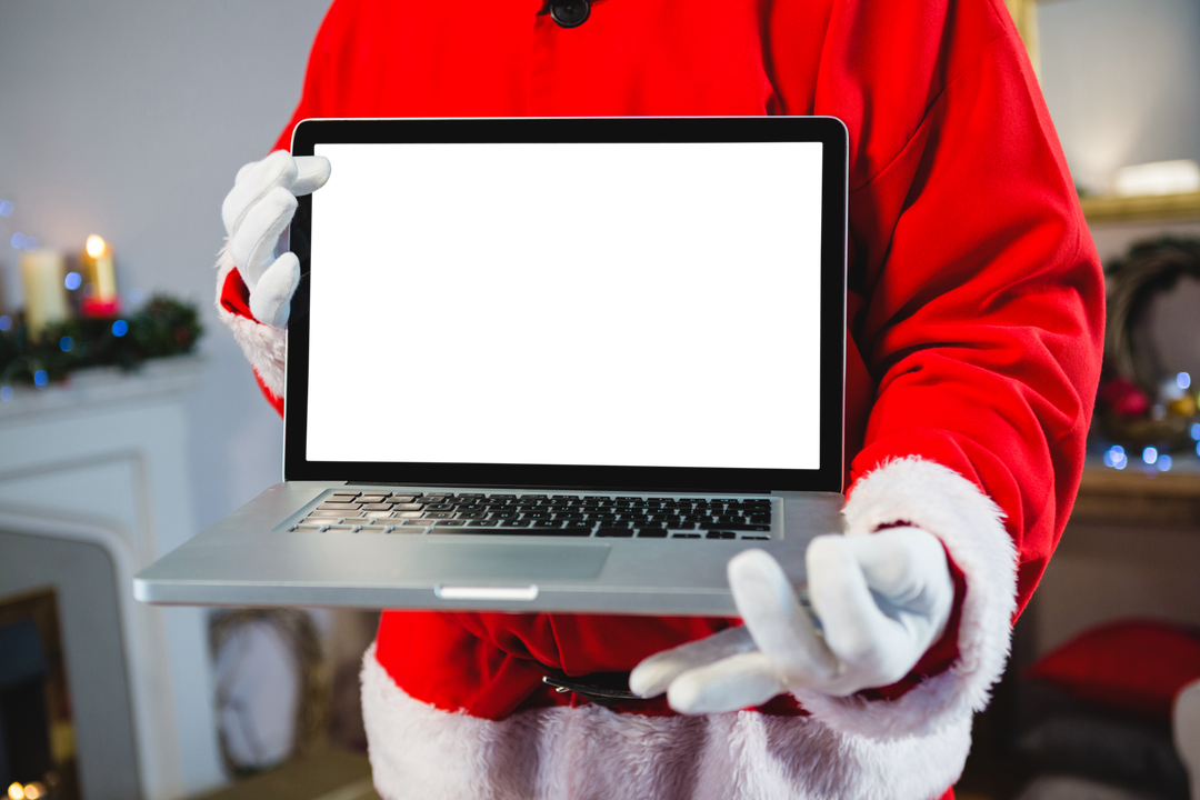 Santa Claus holding black screen laptop in festive setting - Download Free Stock Images Pikwizard.com