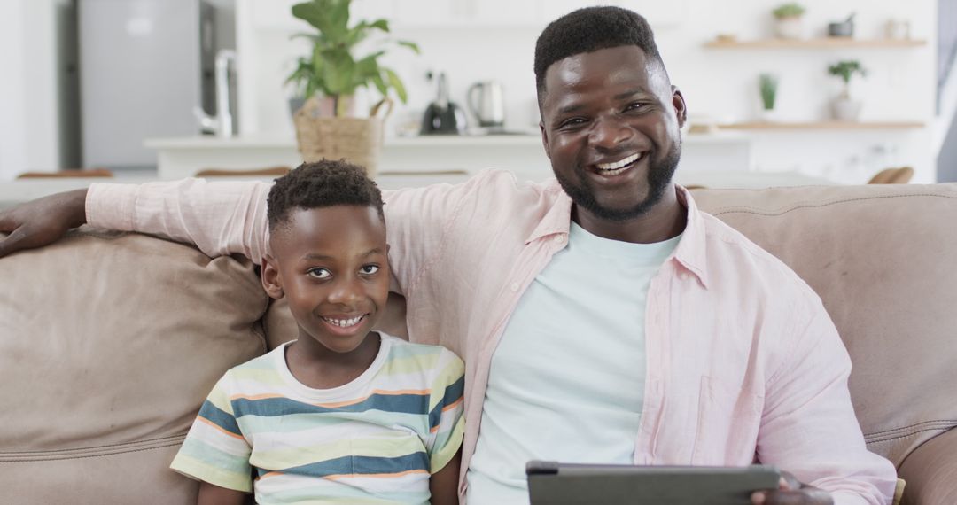 Father and Son Smiling with Tablet in Cozy Home Environment