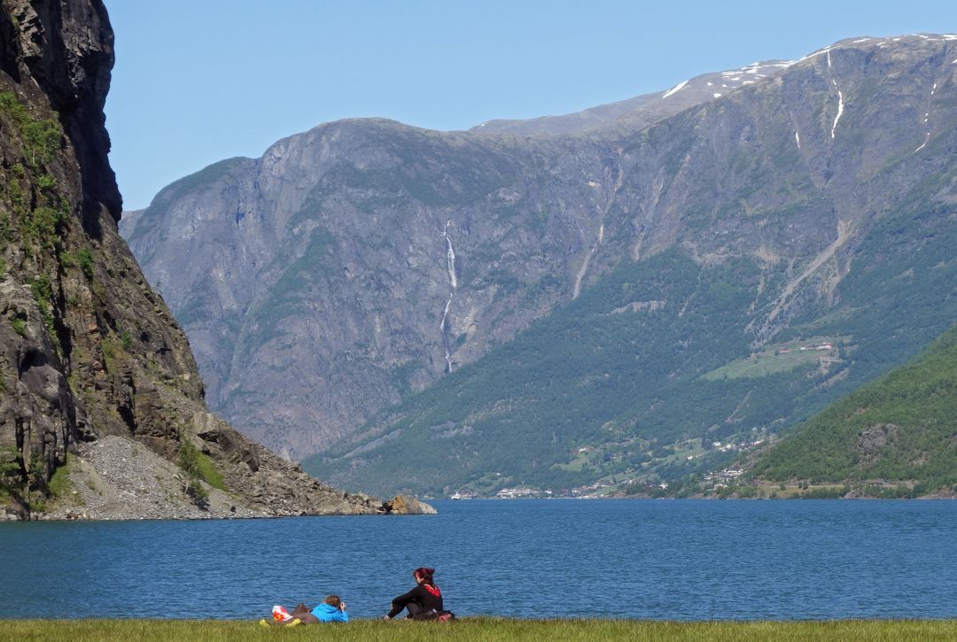 Couple Relaxing by Mountain Lake on Sunny Day - Free Images, Stock Photos and Pictures on Pikwizard.com