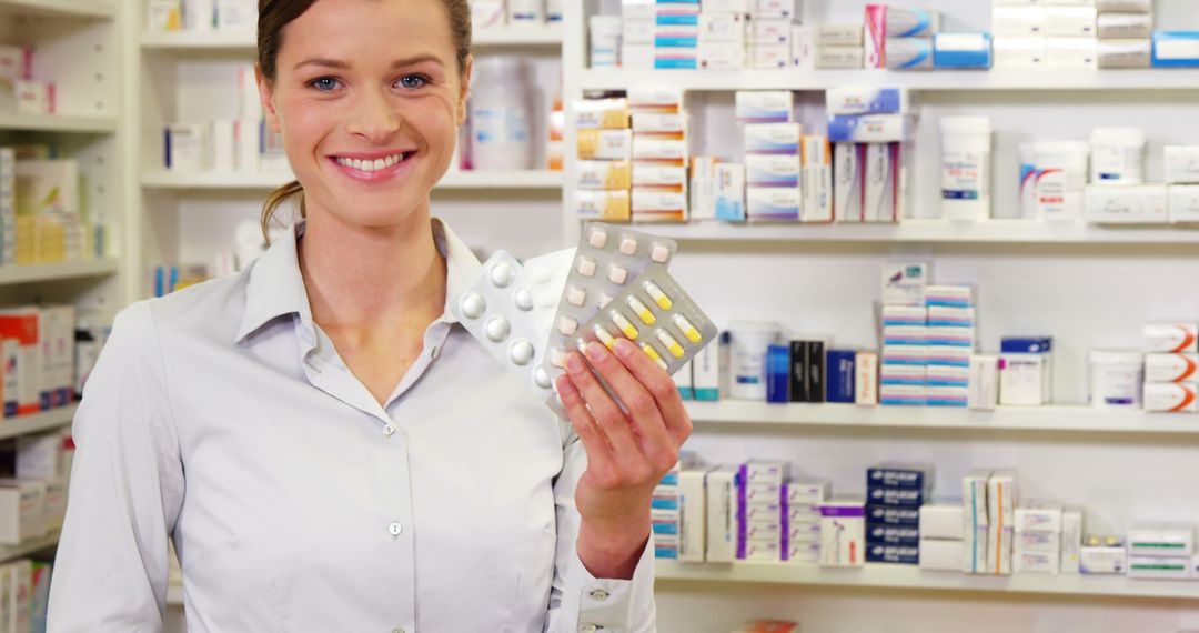 Smiling Pharmacist Holding Medication in Pharmacy - Free Images, Stock Photos and Pictures on Pikwizard.com