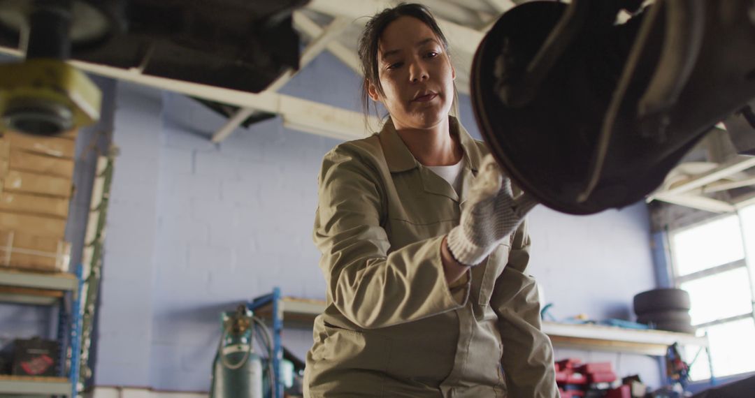 Female Mechanic Focused on Car Repair in Garage Workshop