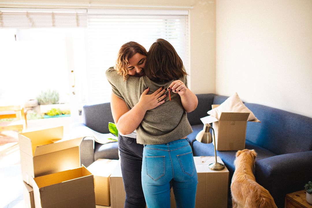 Lesbian couple hugging in living room during moving in - Free Images, Stock Photos and Pictures on Pikwizard.com