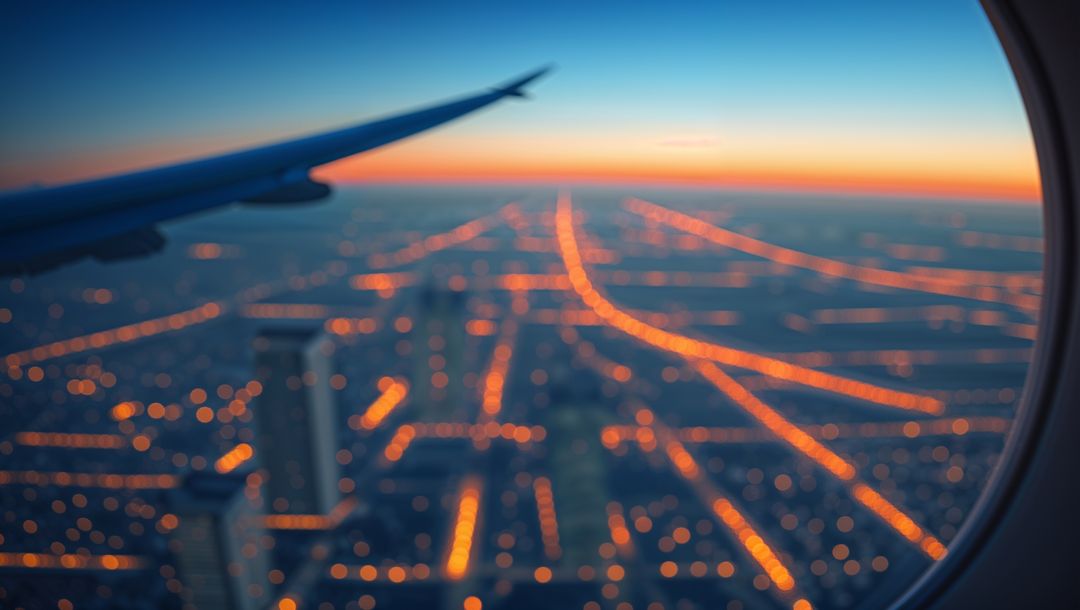 View of City Streets and Airplane Wing at Twilight from Cabin Window
