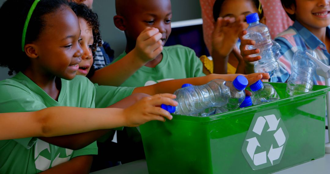 Front view of group of diverse schoolkids putting bottles in recycle container at desk in classroom - Free Images, Stock Photos and Pictures on Pikwizard.com
