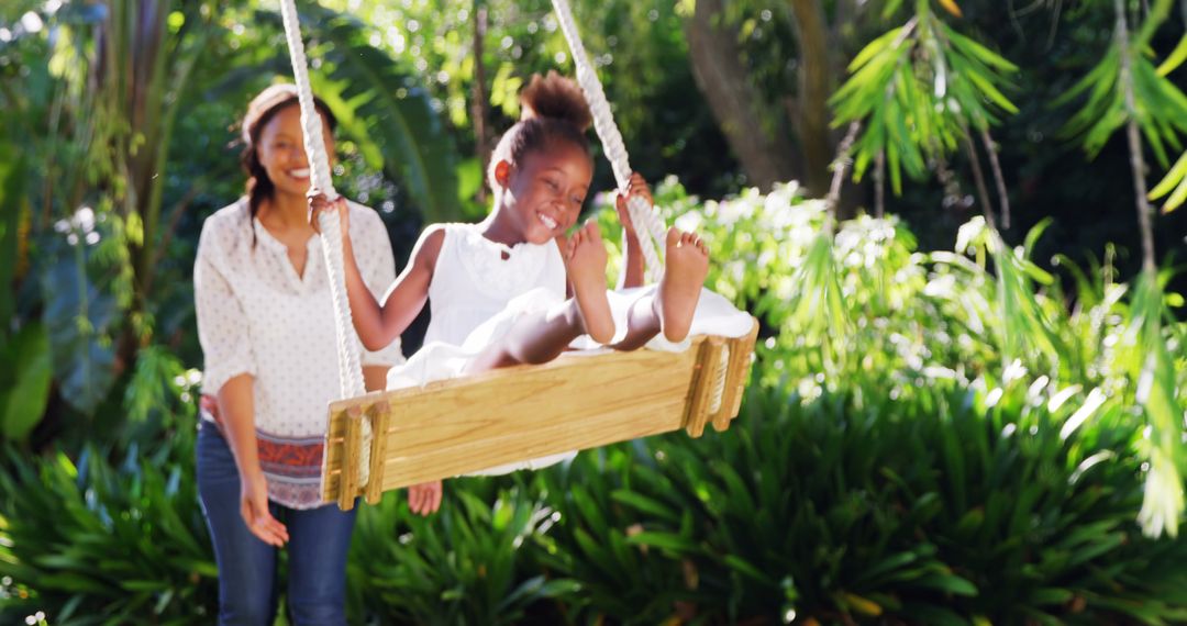 Carefree African American Girl Swinging Outdoors with Her Mother - Free Images, Stock Photos and Pictures on Pikwizard.com