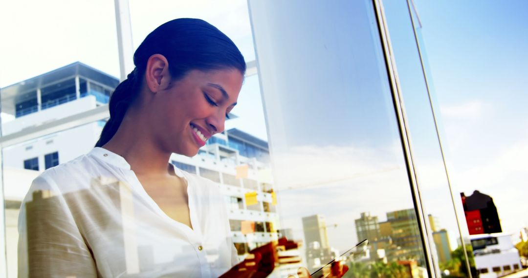 Businesswoman Smiling While Using Tablet in Modern Office - Free Images, Stock Photos and Pictures on Pikwizard.com