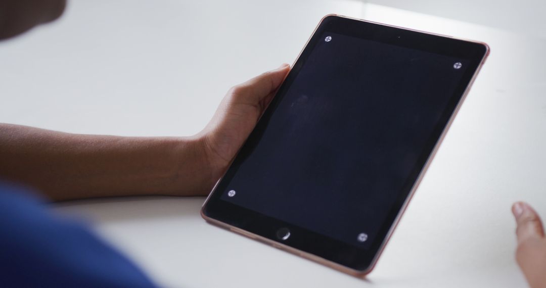 Person Holding Tablet on White Desk - Free Images, Stock Photos and Pictures on Pikwizard.com