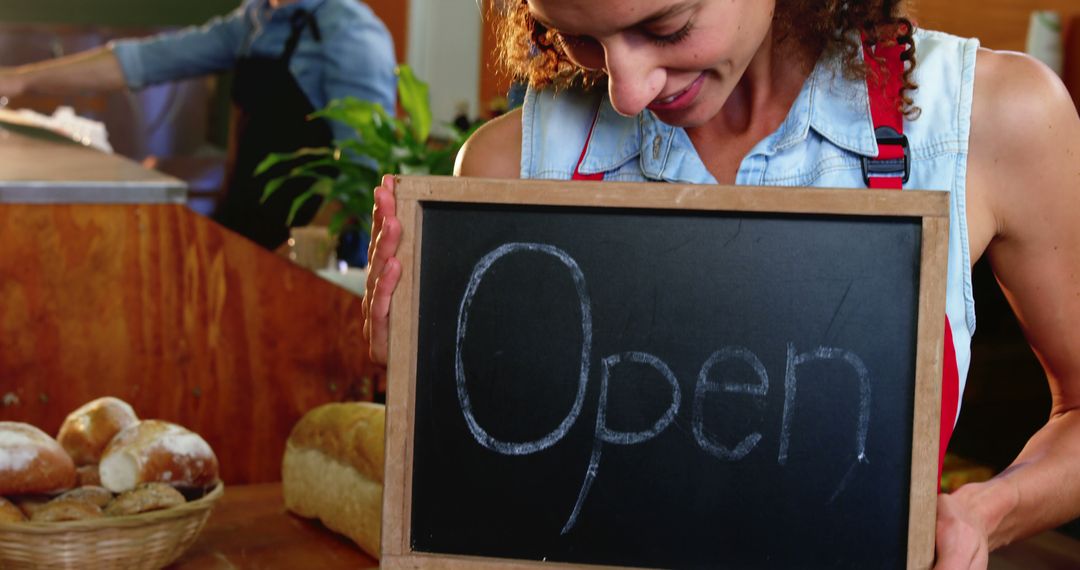 Smiling Woman Holding Open Sign in Bakery - Free Images, Stock Photos and Pictures on Pikwizard.com