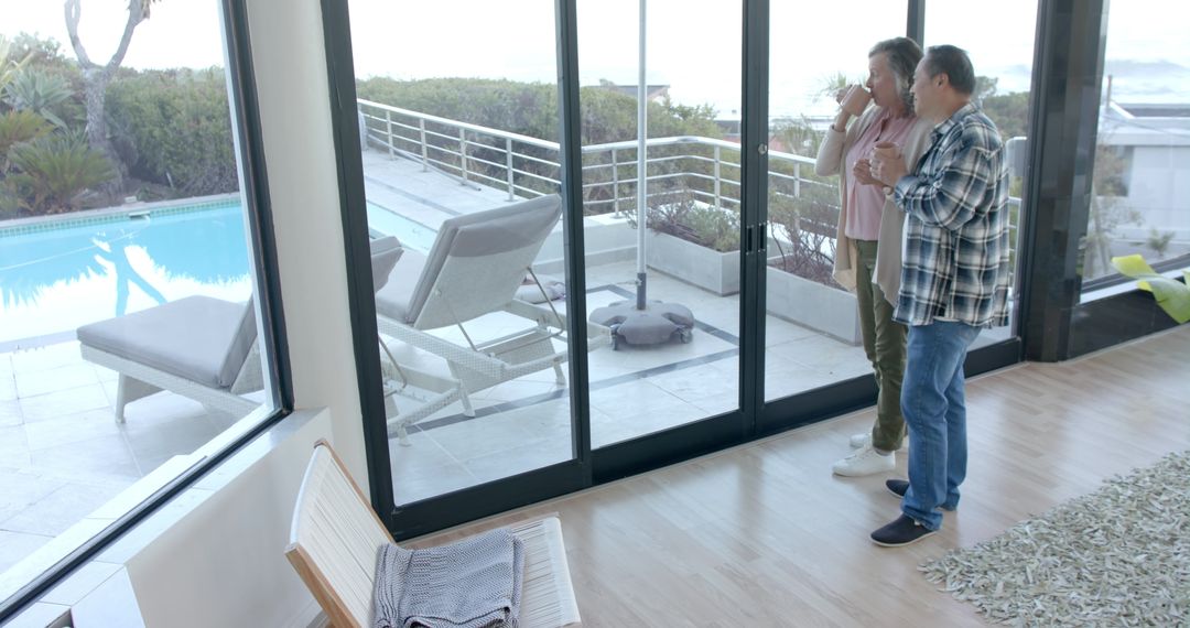 Diverse Couple Enjoying Tranquil Poolside View from Elegant Home