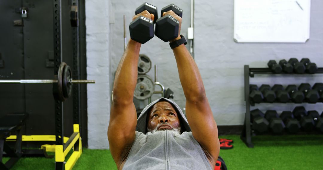 Senior African American male lifting dumbbells at gym - Free Images, Stock Photos and Pictures on Pikwizard.com