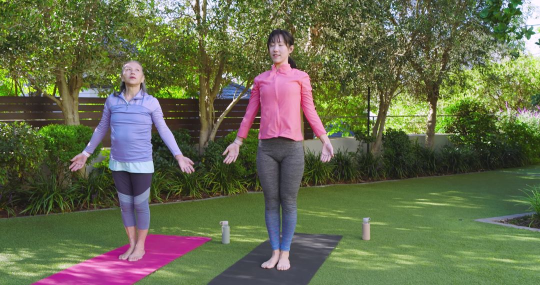 Mother and Daughter Practicing Yoga Outdoors in Serene Garden