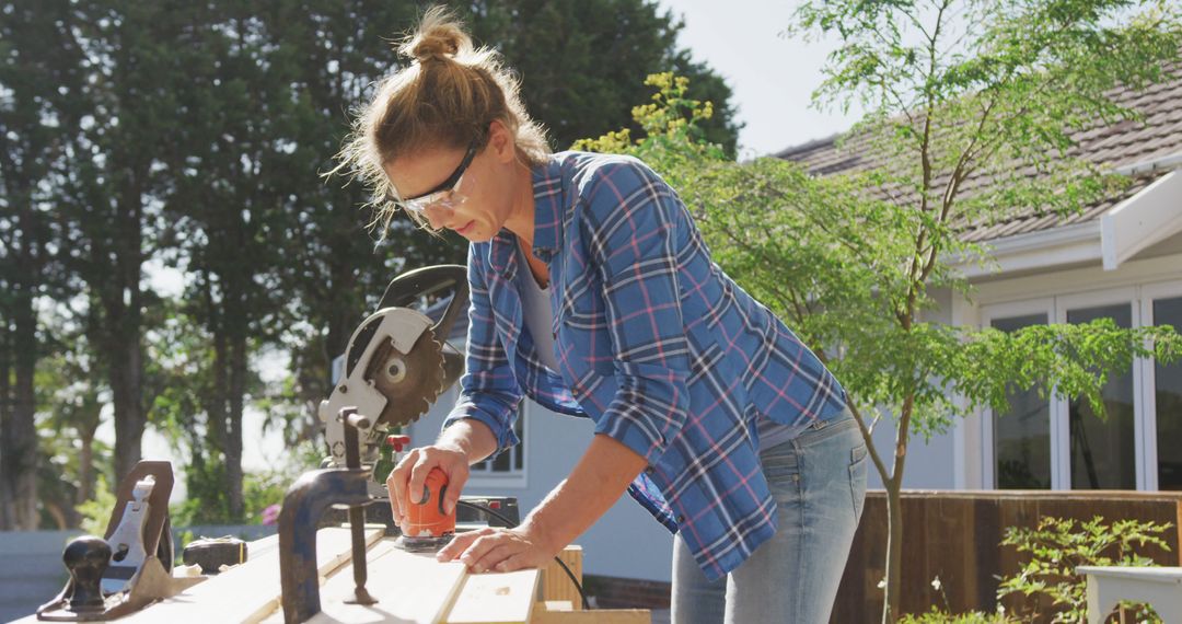 Woman in Plaid Shirt Engaged in Woodworking Outdoors - Free Images, Stock Photos and Pictures on Pikwizard.com