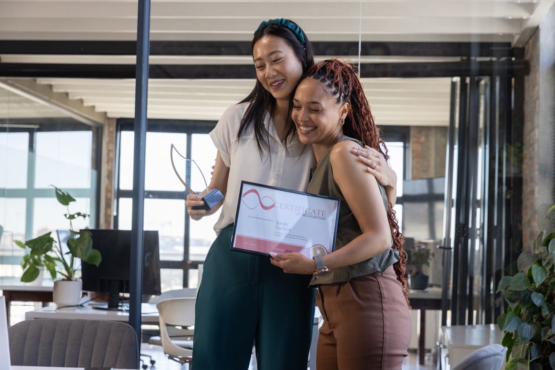 Diverse Female Colleagues Celebrating Success with Trophy and Certificate