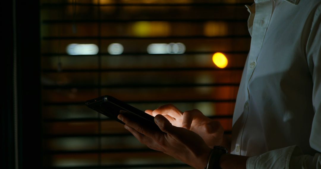 Man Typing on Smartphone in Dimly Lit Environment - Free Images, Stock Photos and Pictures on Pikwizard.com