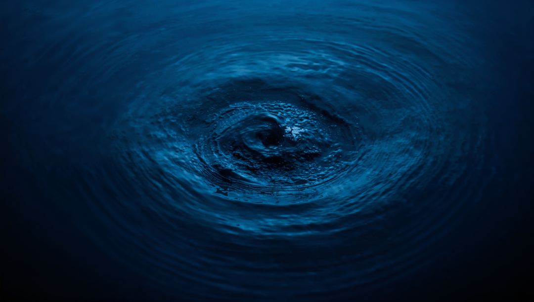 Dark Blue Vortex with Concentric Ripples in Night Water