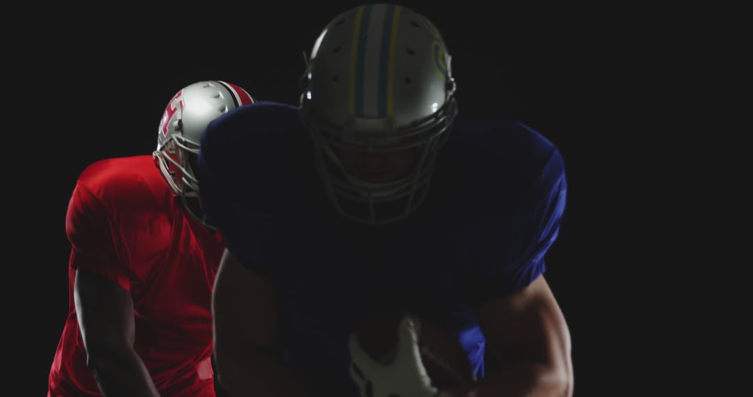 American Football Players Preparing For Play in Dark Studio - Free Images, Stock Photos and Pictures on Pikwizard.com