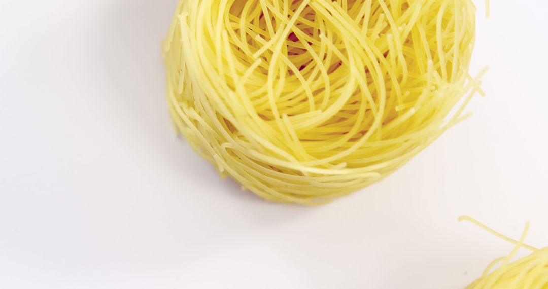 Fresh uncooked nest of spaghetti on white background - Free Images, Stock Photos and Pictures on Pikwizard.com