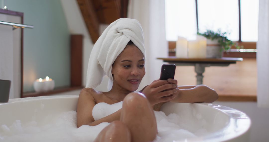 Biracial woman taking a bath and using smartphone - Free Images, Stock Photos and Pictures on Pikwizard.com