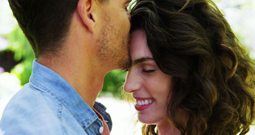 A young couple displays affection, hinting at romance with a forehead kiss. - Free Images, Stock Photos and Pictures on Pikwizard.com