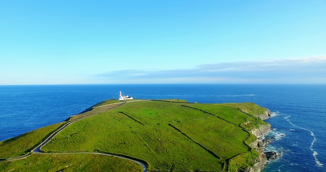 A serene aerial shot captures a lighthouse amid greenery against a tranquil ocean backdrop. - Free Images, Stock Photos and Pictures on Pikwizard.com